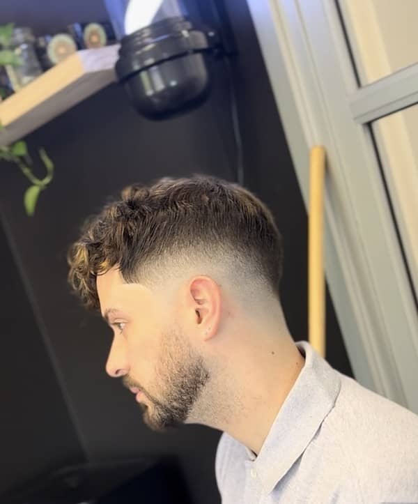 Curly top hairstyle with skin fade, styled by Clipper Cole barber in Charlotte, NC
